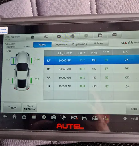 About Coastal Tyre Services: Diagnostic tool screen displays tire pressure monitoring system data for a Vauxhall vehicle, showing individual tire pressures, IDs, and sensor statuses for all four tires.
